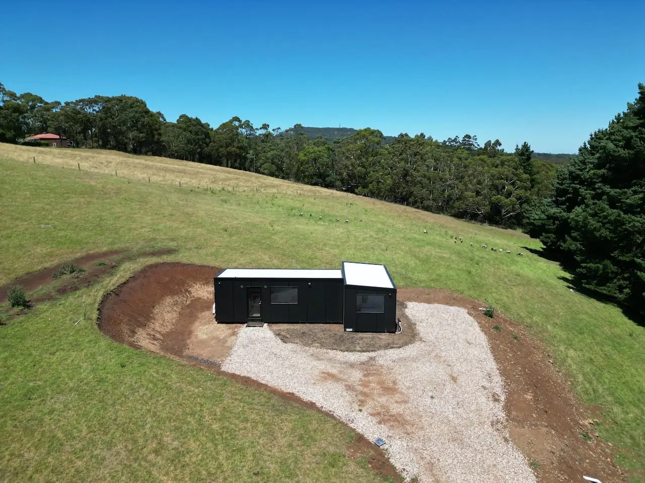 Aerial photograph of a MicroHome on a rural block with a roof solar array and a garden beside it.
