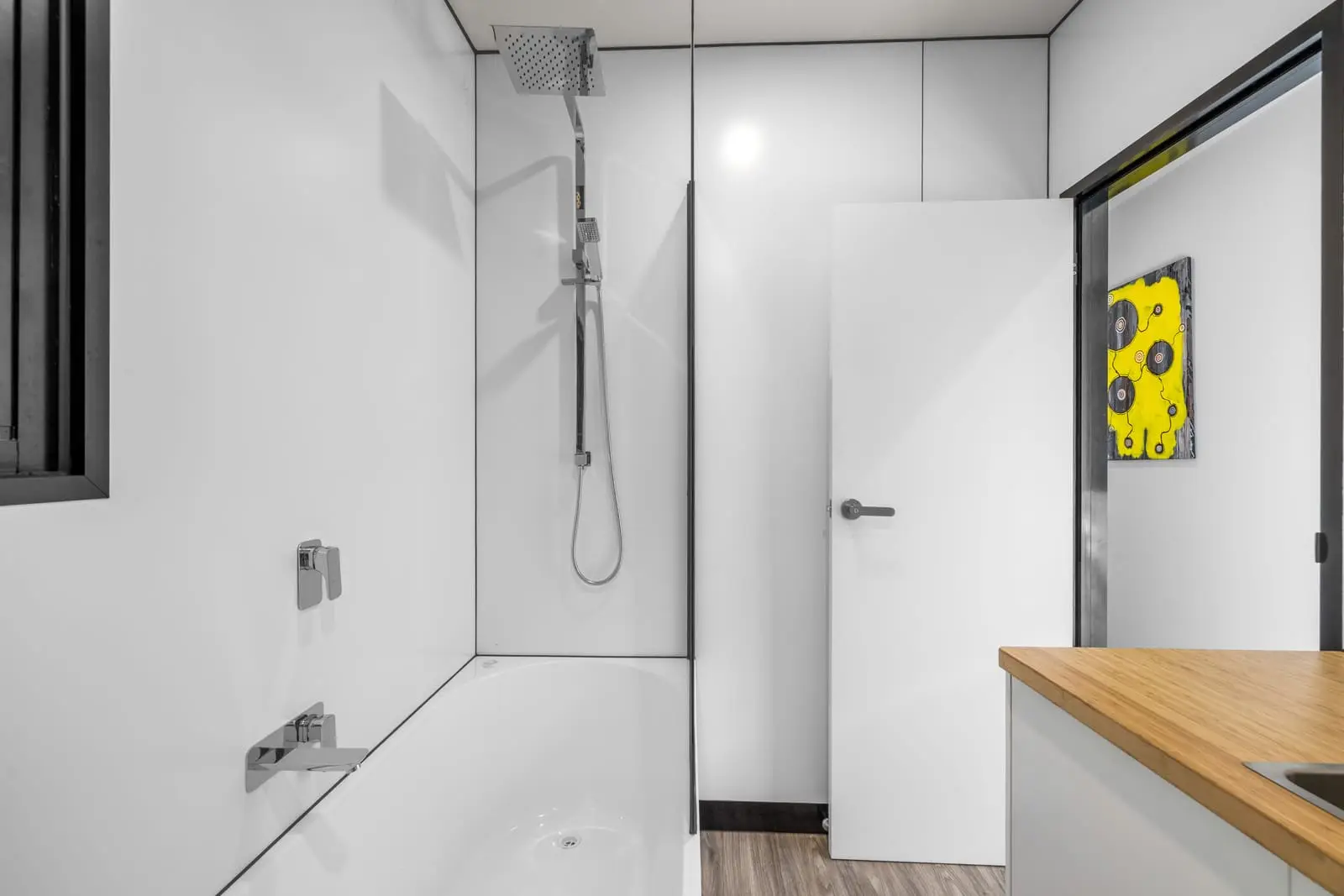 The shower in a MicroHome bathroom, beside the door through to the bedroom.