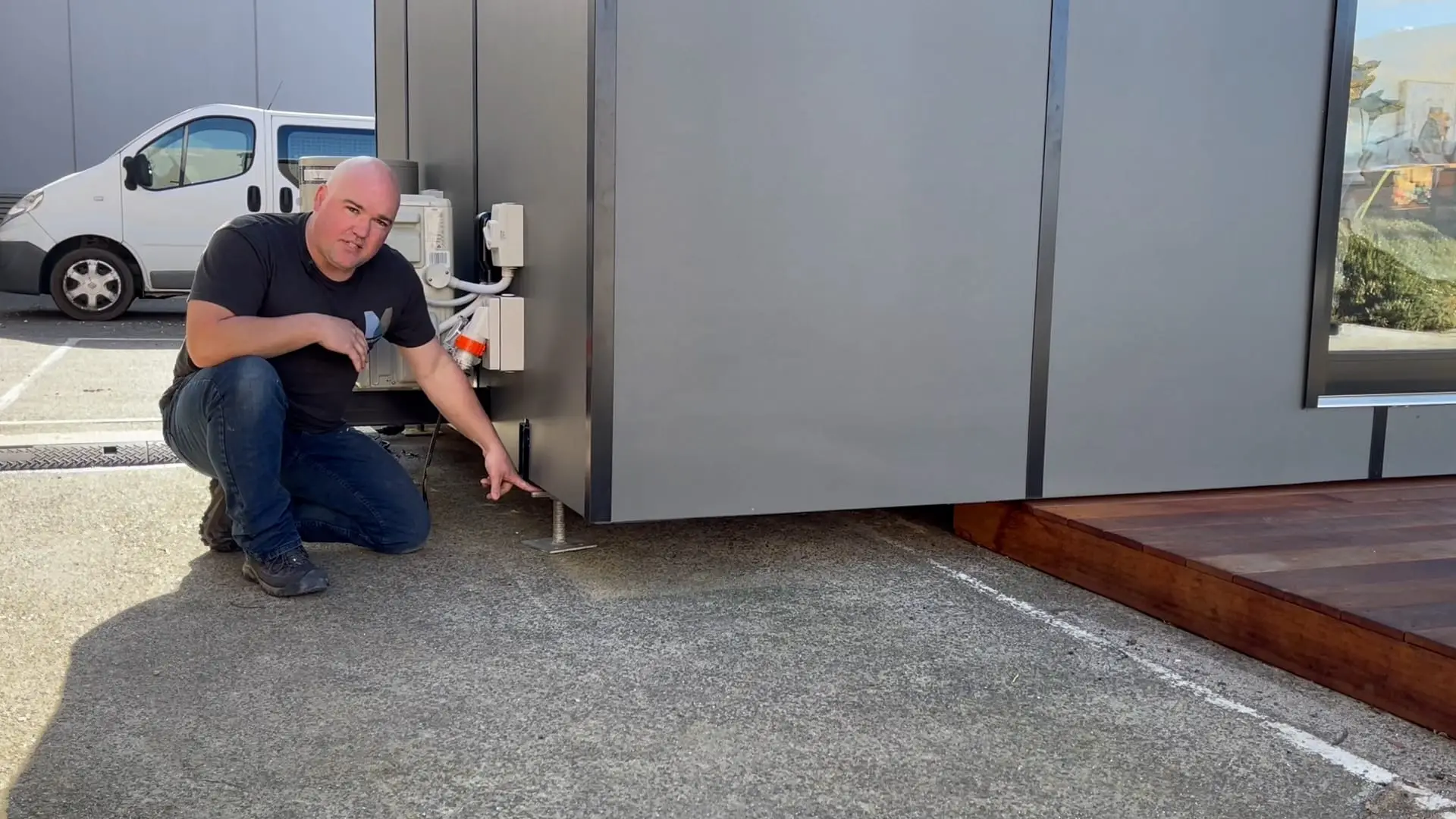 A MicroHomes team member checking the engineered steel chassis beneath a home under construction.