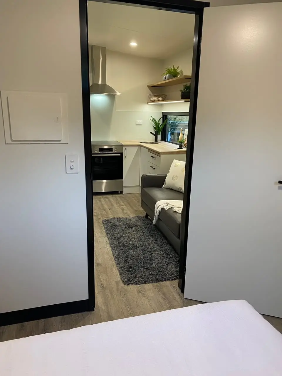 The view through a MicroHome from the bedroom end, past the robes to the kitchen.