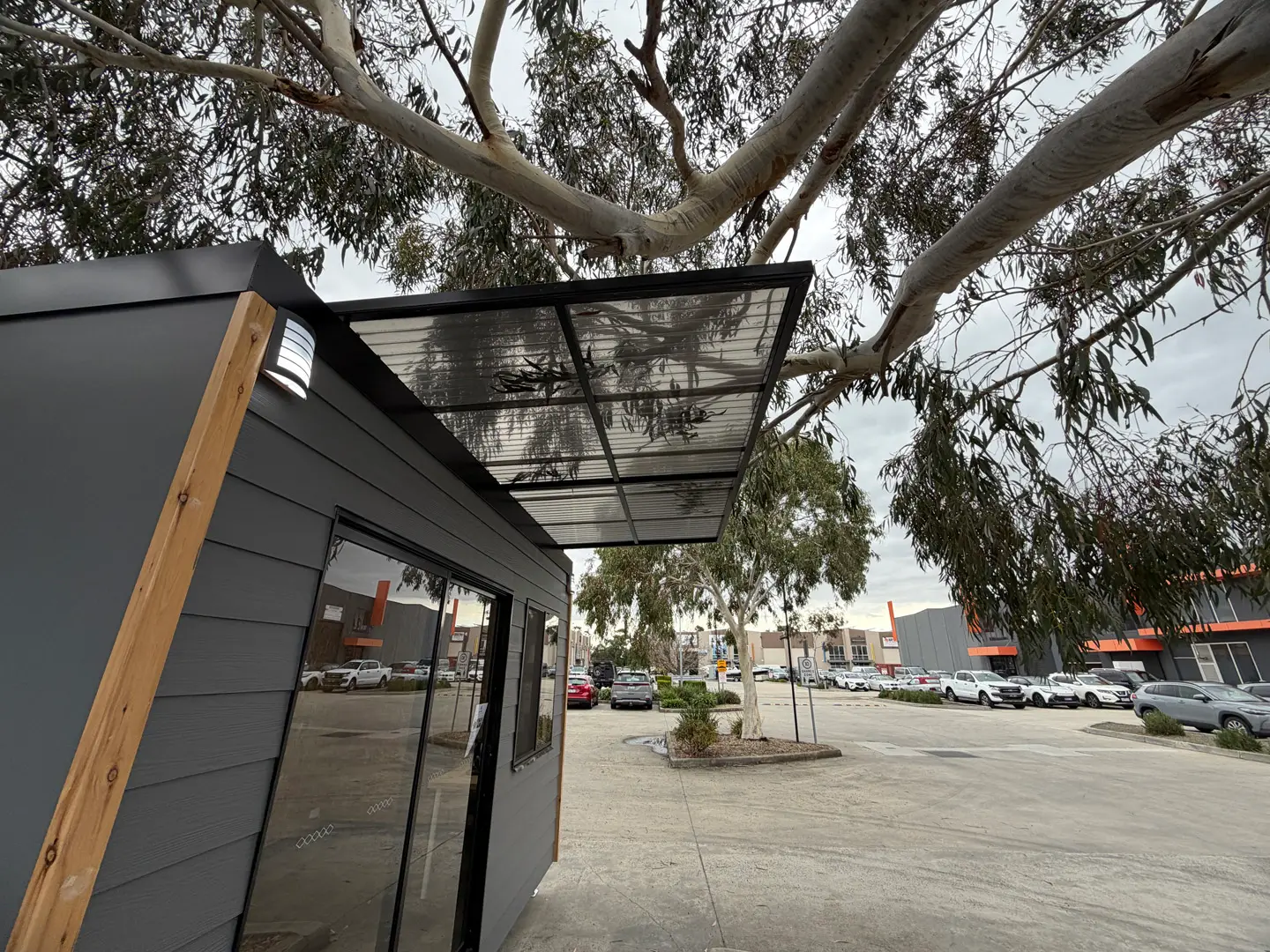 The slide-out awning extended over the entry of the ex-demo Backyard Pod, under a eucalypt.