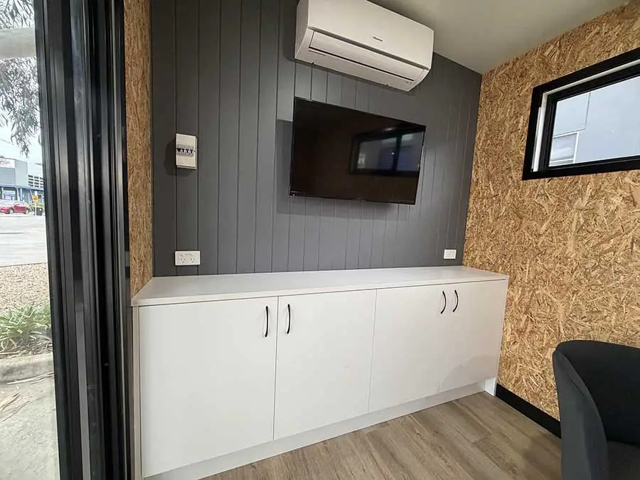 Custom cabinetry and a wall-mounted screen built into the wall of a Backyard Pod.