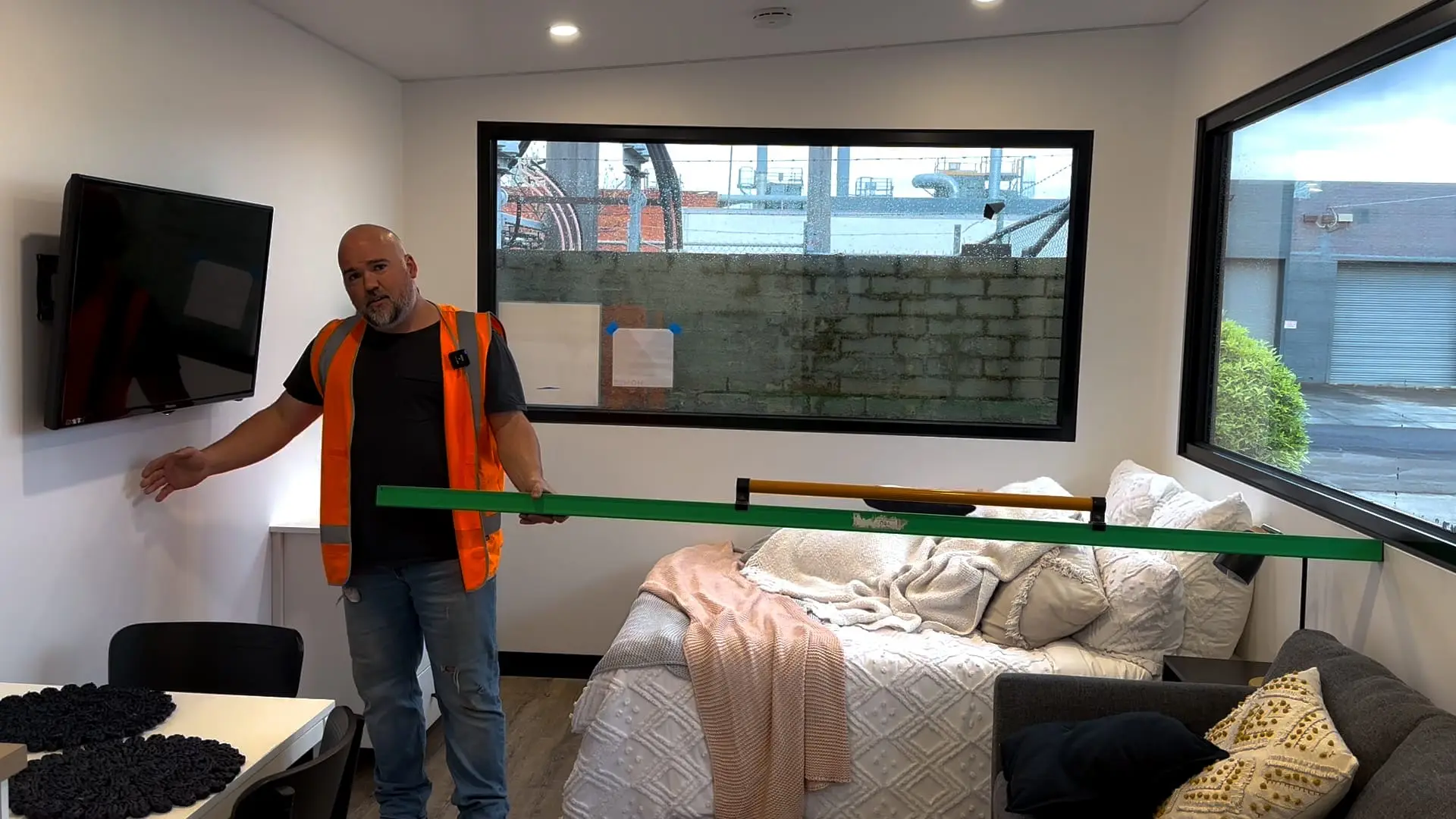A MicroHomes team member measuring the internal width of a MicroHome with a tape.